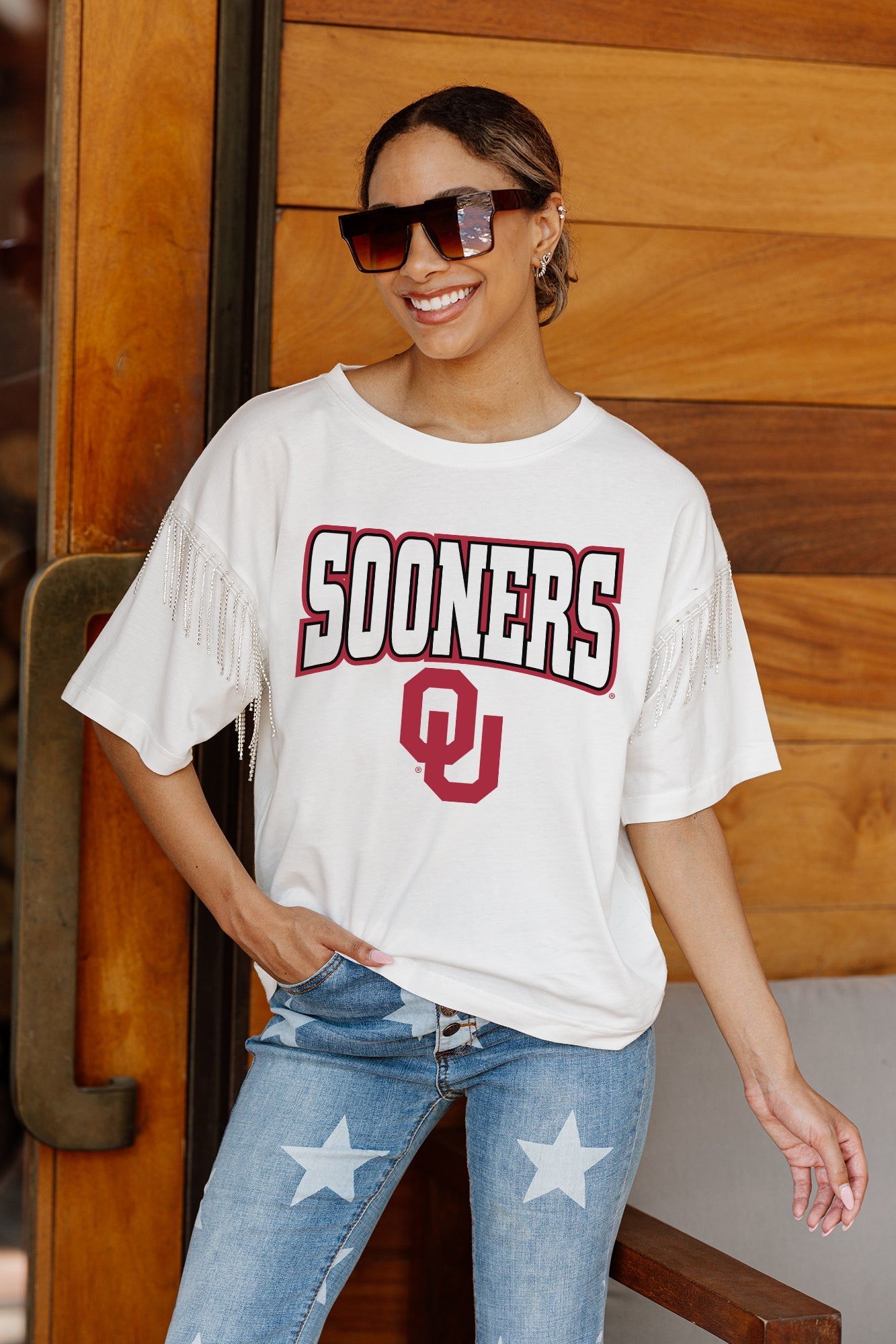 OKLAHOMA SOONERS IRRESISTIBLE SHORT SLEEVE RHINESTONE FRINGE TEE WITH RIBBED NECKLINE