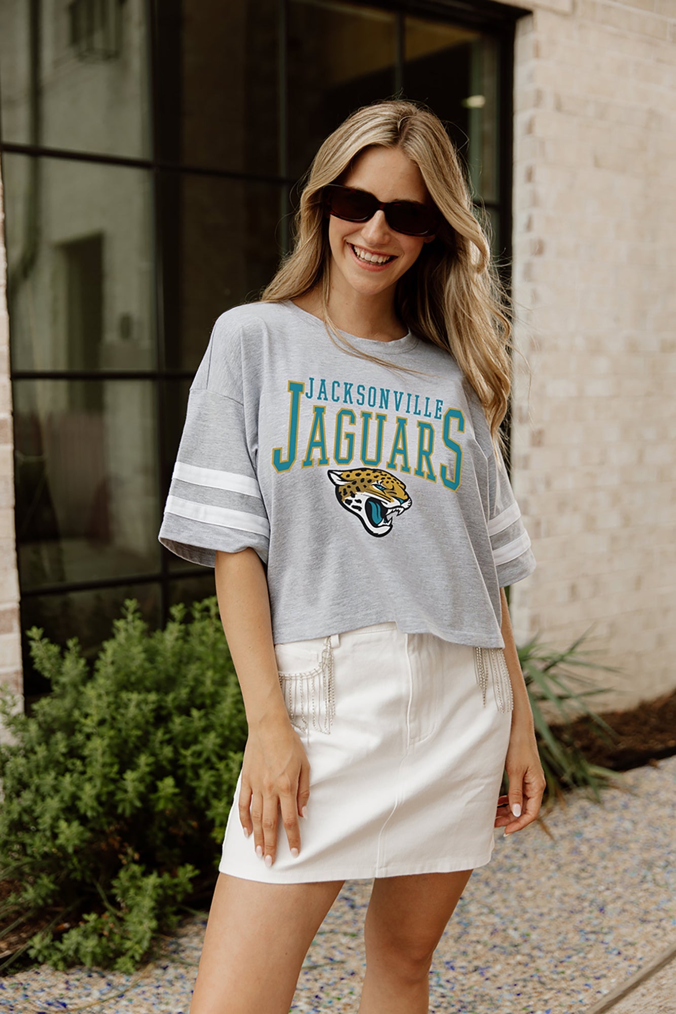 JACKSONVILLE JAGUARS GRIDIRON GLAM SHORT SLEEVE CROP TEE WITH SPORT STRIPE DETAIL