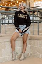 NEW ORLEANS SAINTS GAMEDAY GLITZ LONG SLEEVE TEE WITH SEQUIN TRIM BACK AND SLEEVE DETAIL